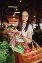 妇女在本地的室内市场用柳条篮挑选新鲜农产品