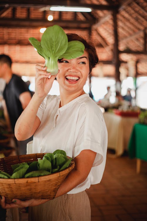 Happy ethnic woman with salad leaf