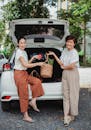 SMiling Women Standing beside Car's Compartment