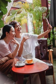 两个女人在舒适的咖啡馆里喝着咖啡自拍