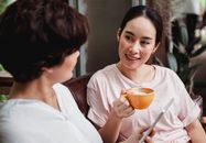 两名妇女在舒适的室内环境中一边喝咖啡一边友好地交谈
