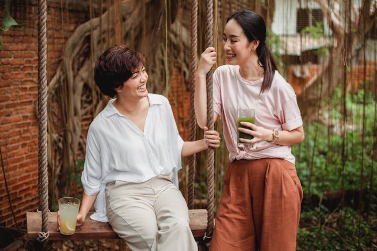 Happy Asian Friends Resting In Garden