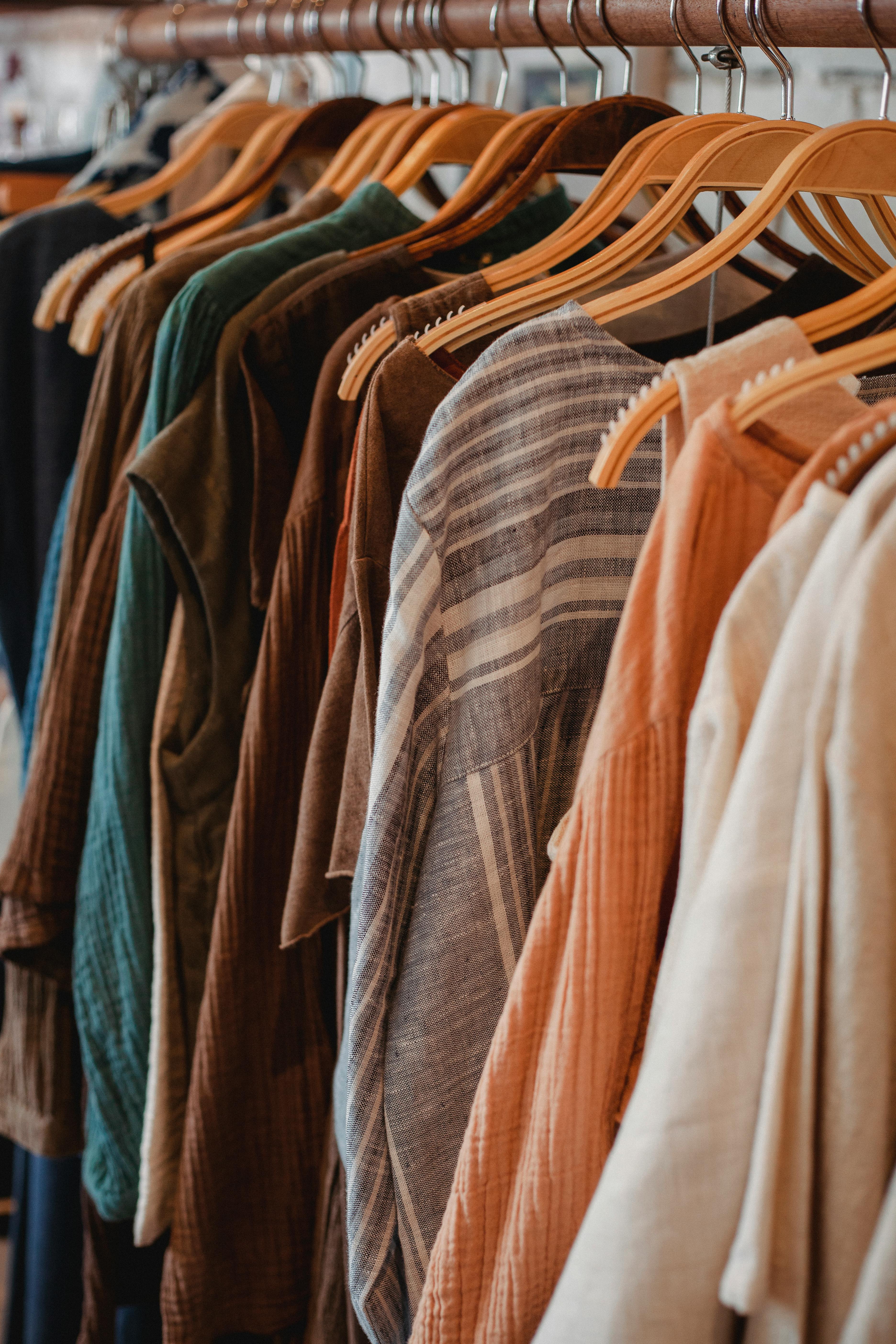 Colorful Wooden Cloth Hangers On Clothes Rail On White Defocused