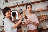年轻的少数民族女性购物者在商店货架旁看着装饰镜