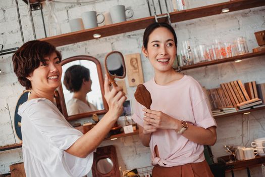 年轻的少数民族女性购物者在商店货架旁看着装饰镜
