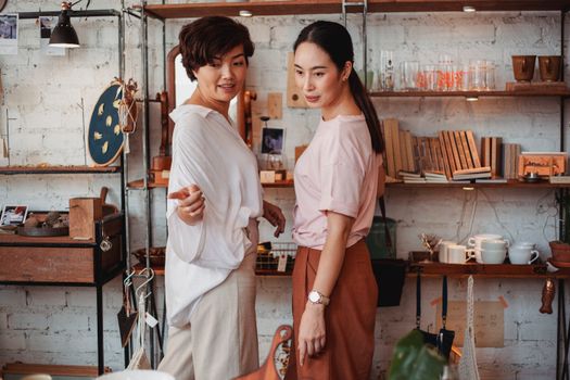 两位亚洲女性在一家时尚的室内精品店里购物互动，店里提供各种厨具和装饰品