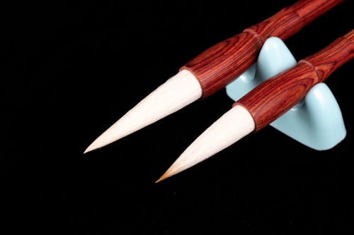 From above closeup of different Japanese calligraphy brush pens with pointed tips and bamboo shafts