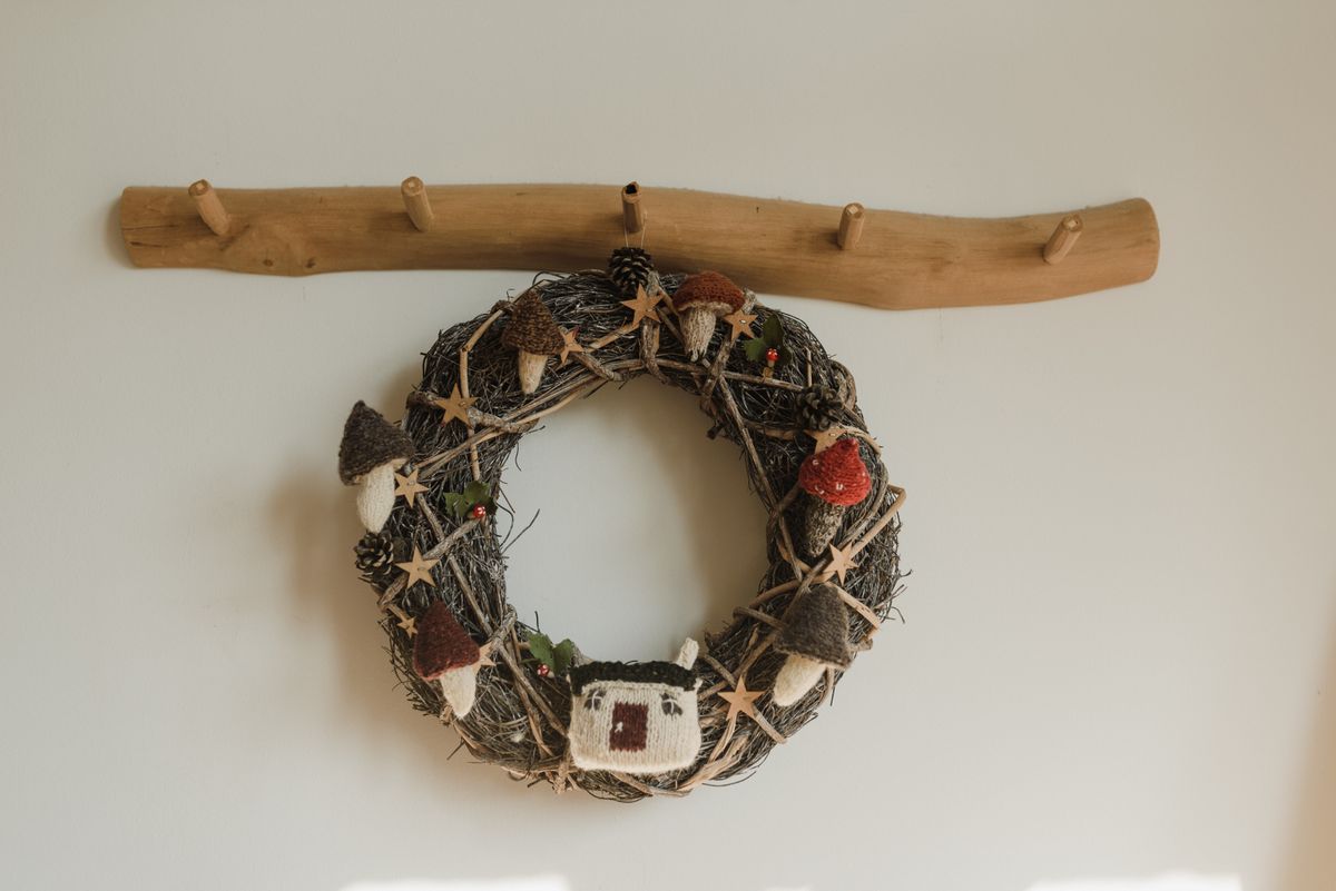 Christmas wreath hanging on a wooden coat hook rail