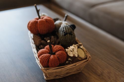 Free Warm autumn decorations featuring knitted pumpkins in a wicker basket. Stock Photo