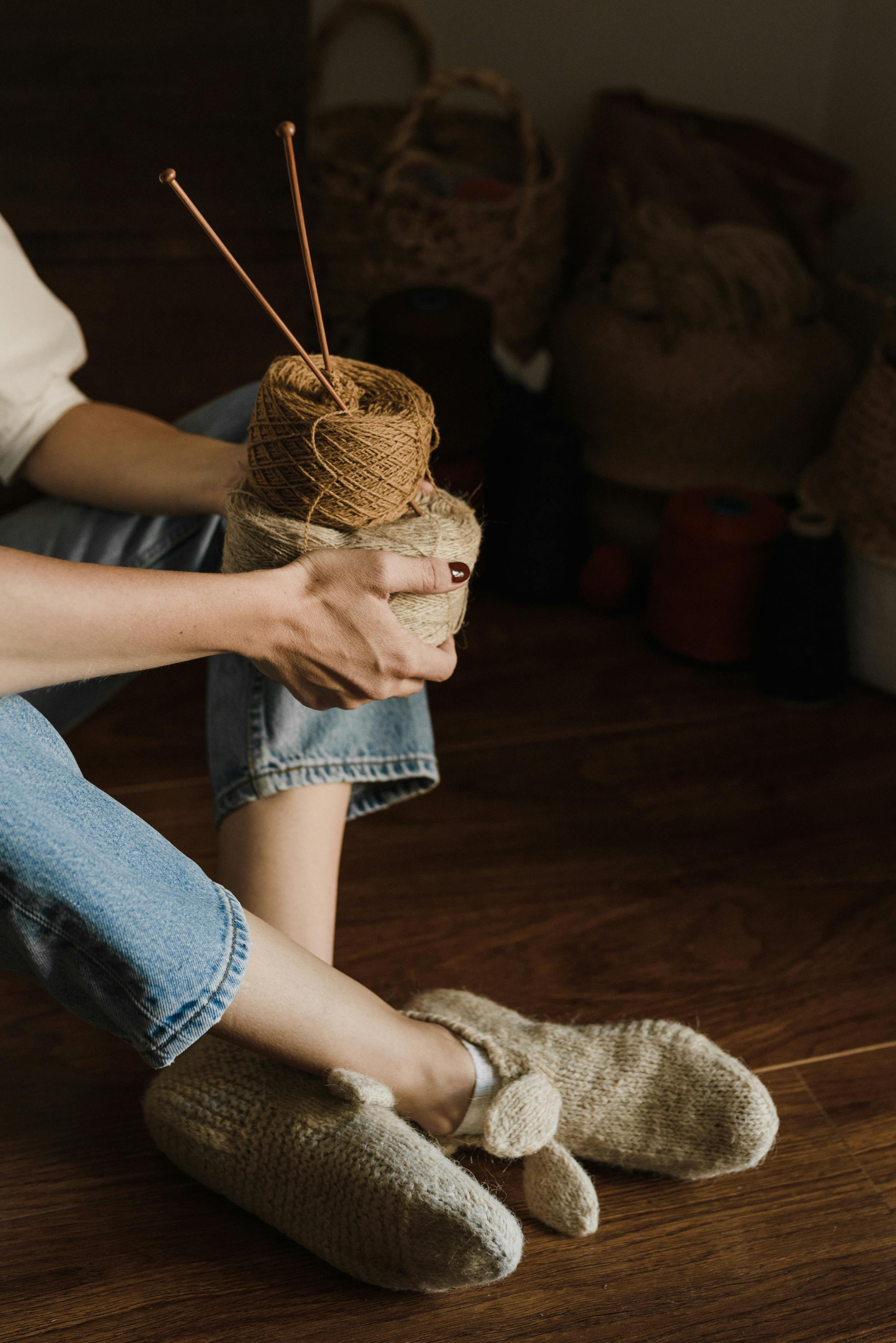 Person Holding a Role of Yarns and Knitting Needles · Free Stock Photo