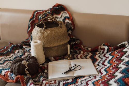 Open Book, Wicker Basket, Woolen Thread on Colored Blanket