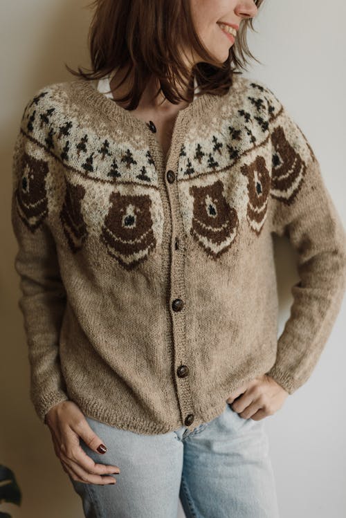 Woman in Brown Knitted Cardigan Leaning on a Wall