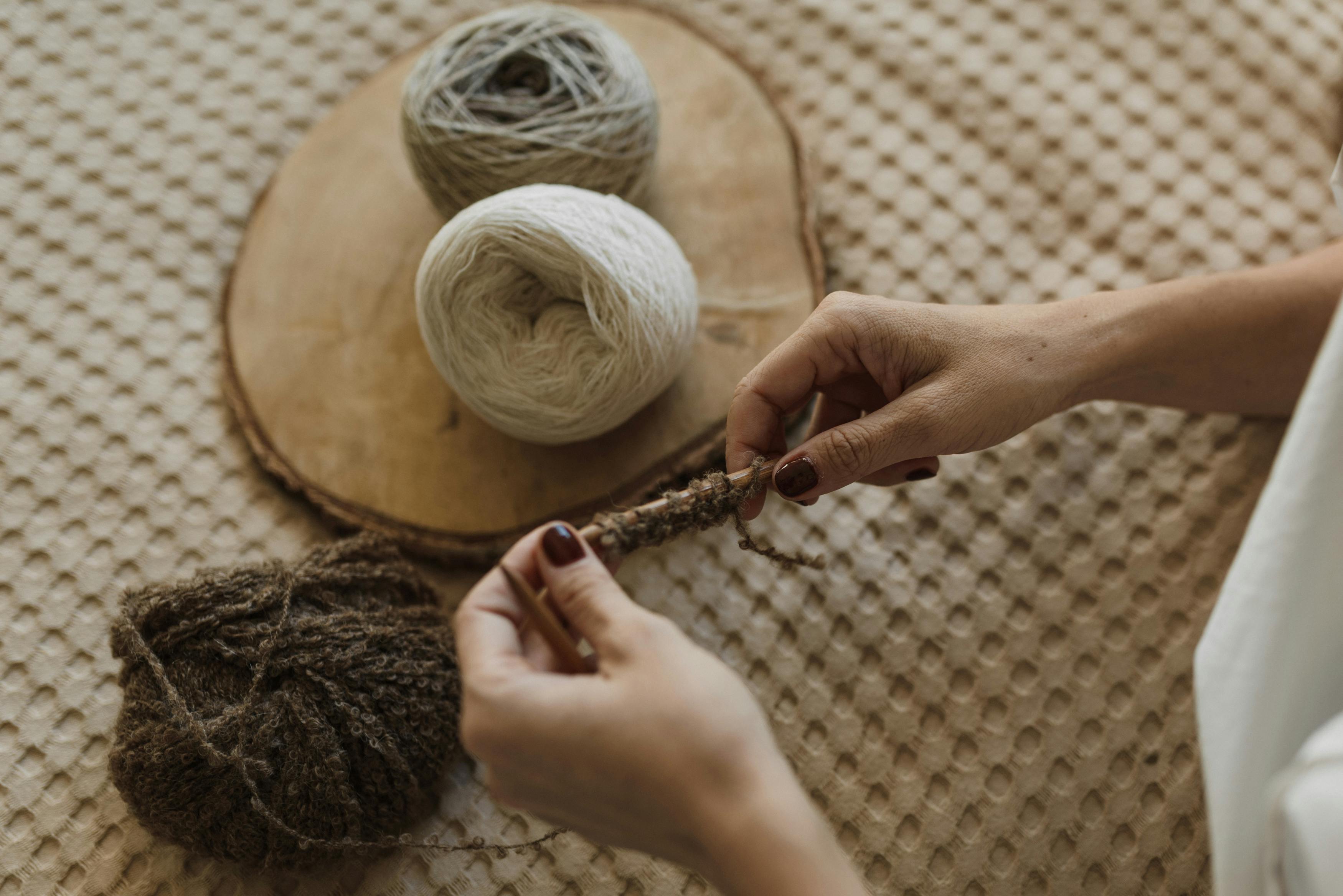 person holding knitting needles with yarn