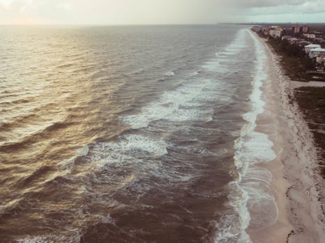日落时分，从空中俯瞰宁静的海滩，波光粼粼，非常适合激发旅行灵感