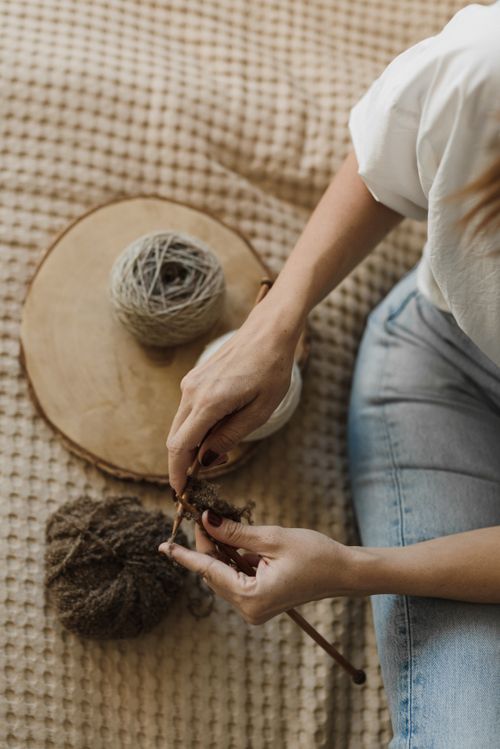 Free A person knitting with brown yarn, showcasing a relaxing indoor hobby. Stock Photo