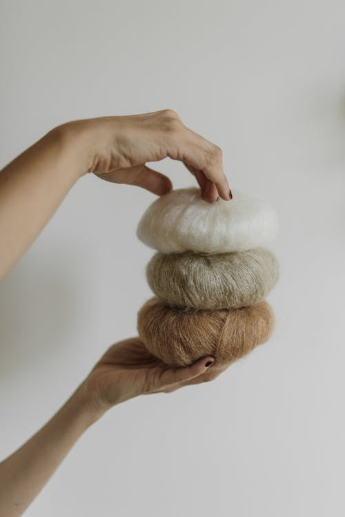 Person Holding Yarn Rolls