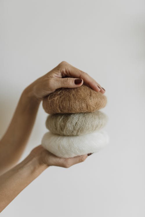 Person Holding Yarn Rolls