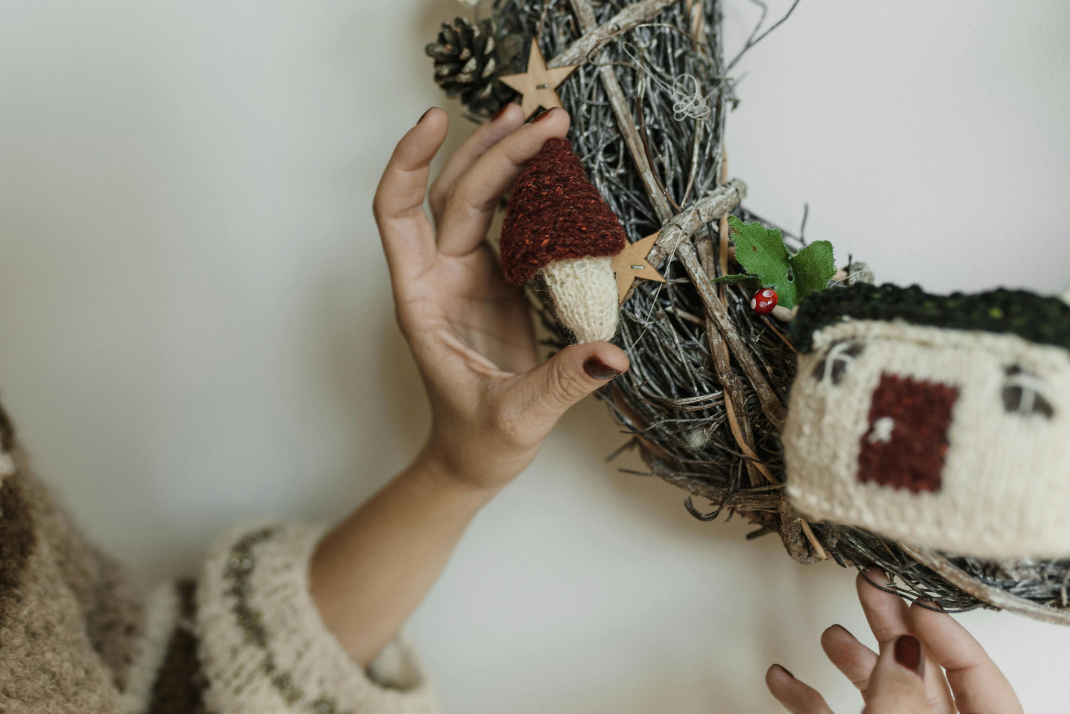 a person holding a knitted christmas ornament