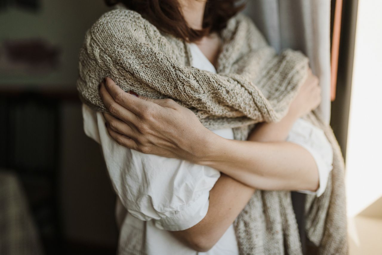 Woman wrapped in chunky knitwear