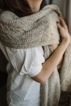 一条手工编织的羊毛围巾包裹着一位女性，带来温暖与舒适