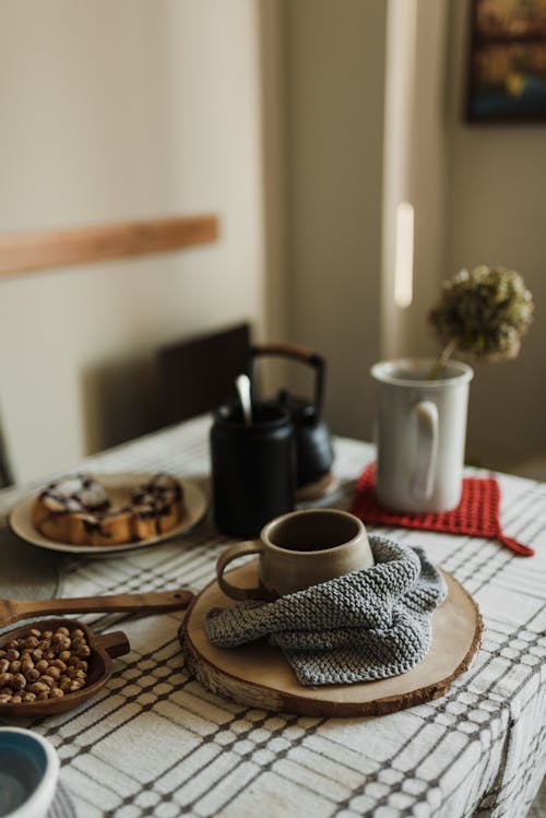 Free Ceramic Mug in Knitted Towel on Wooden Mat Stock Photo