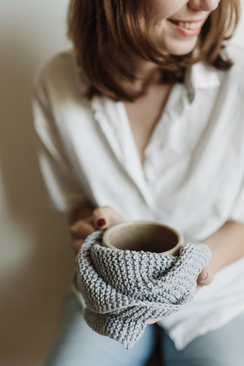 Woman in White Shirt Holding Ceramic Mug