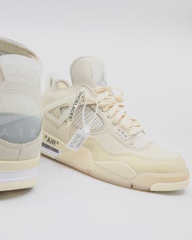 Pair of beige sports shoes displayed on a white studio background.