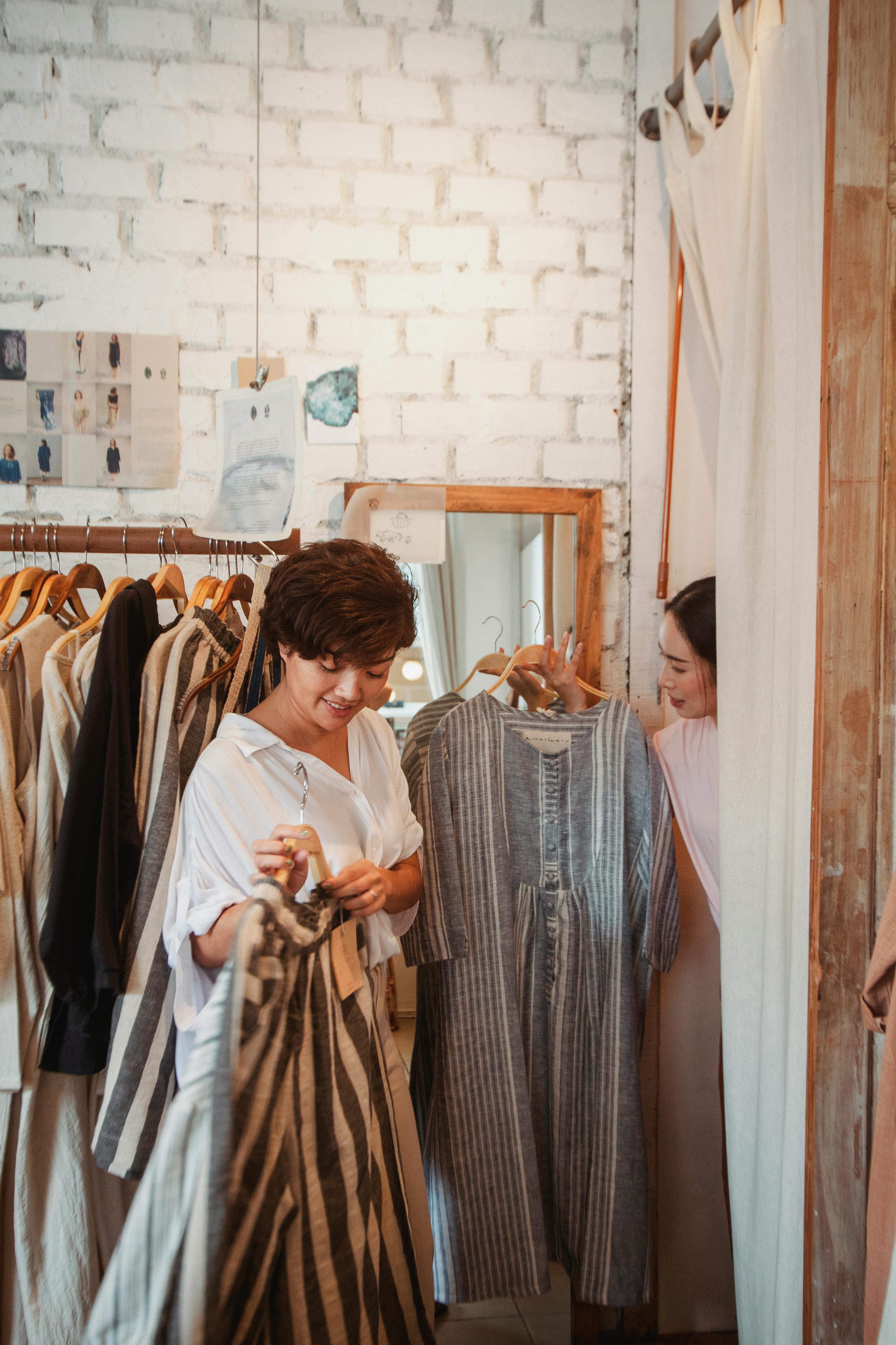 stylish young ethnic female customers exploring new collection of fashion boutique