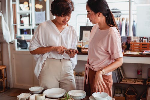 Young Asian women choosing elegant dishware in store