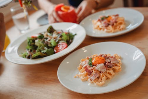 Free Delicious pasta and salad on table Stock Photo