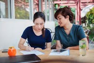 Asian women freelancers discussing work in cafe
