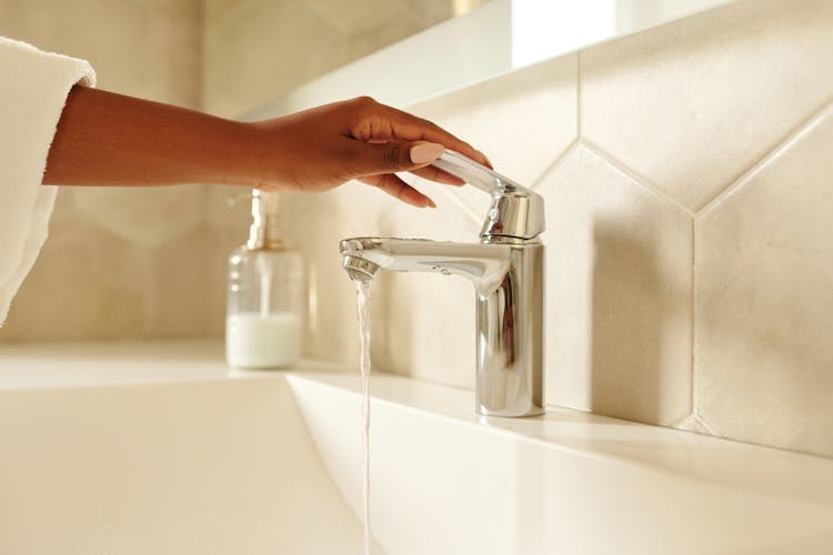 Person Holding Stainless Steel Faucet