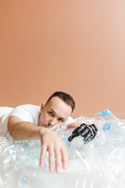Man Lying on Squeezed Plastic Bottles