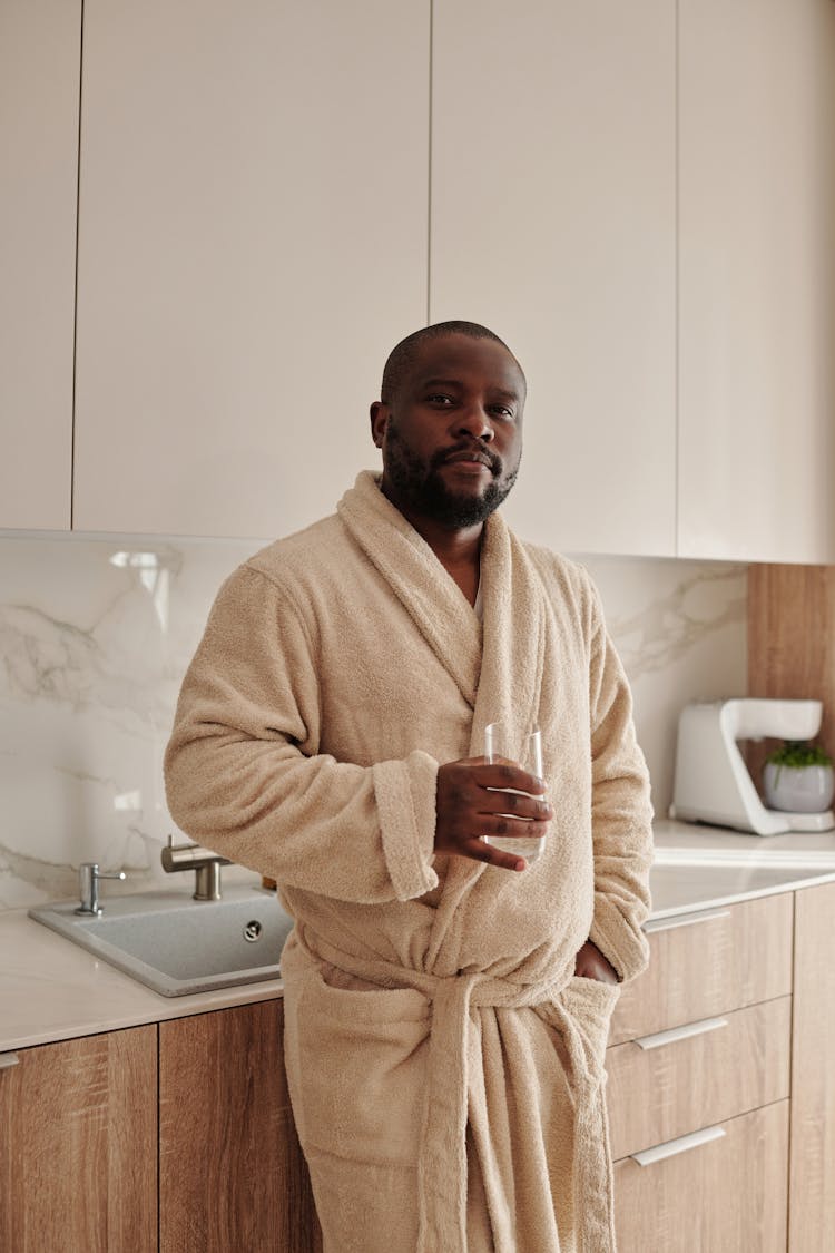 Man Wearing An Bathrobe Holding A Glass Of Water