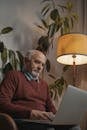 Man in Red Sweater Sitting by the Table