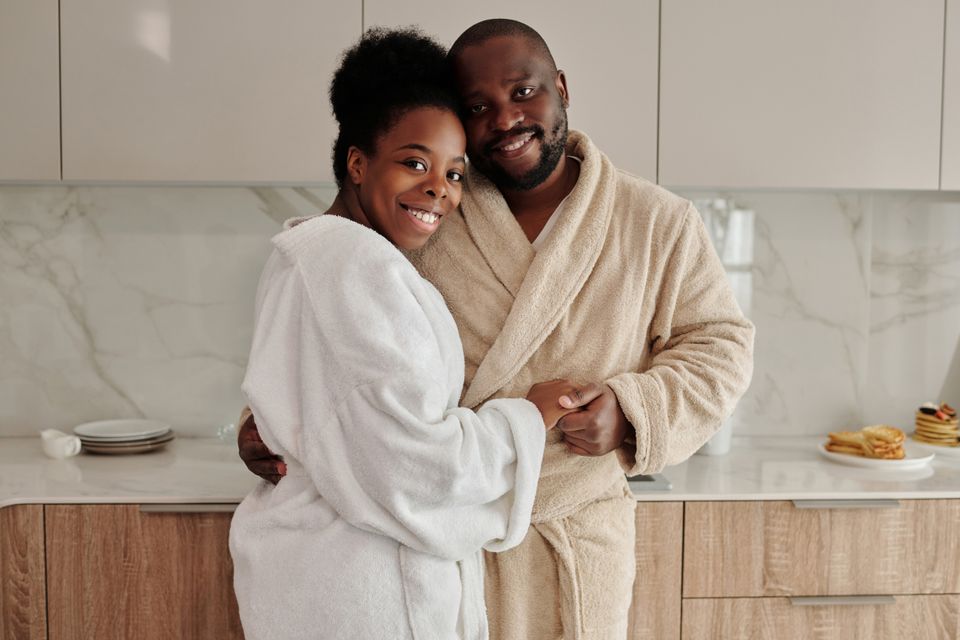 A smiling couple embracing in a kitchen