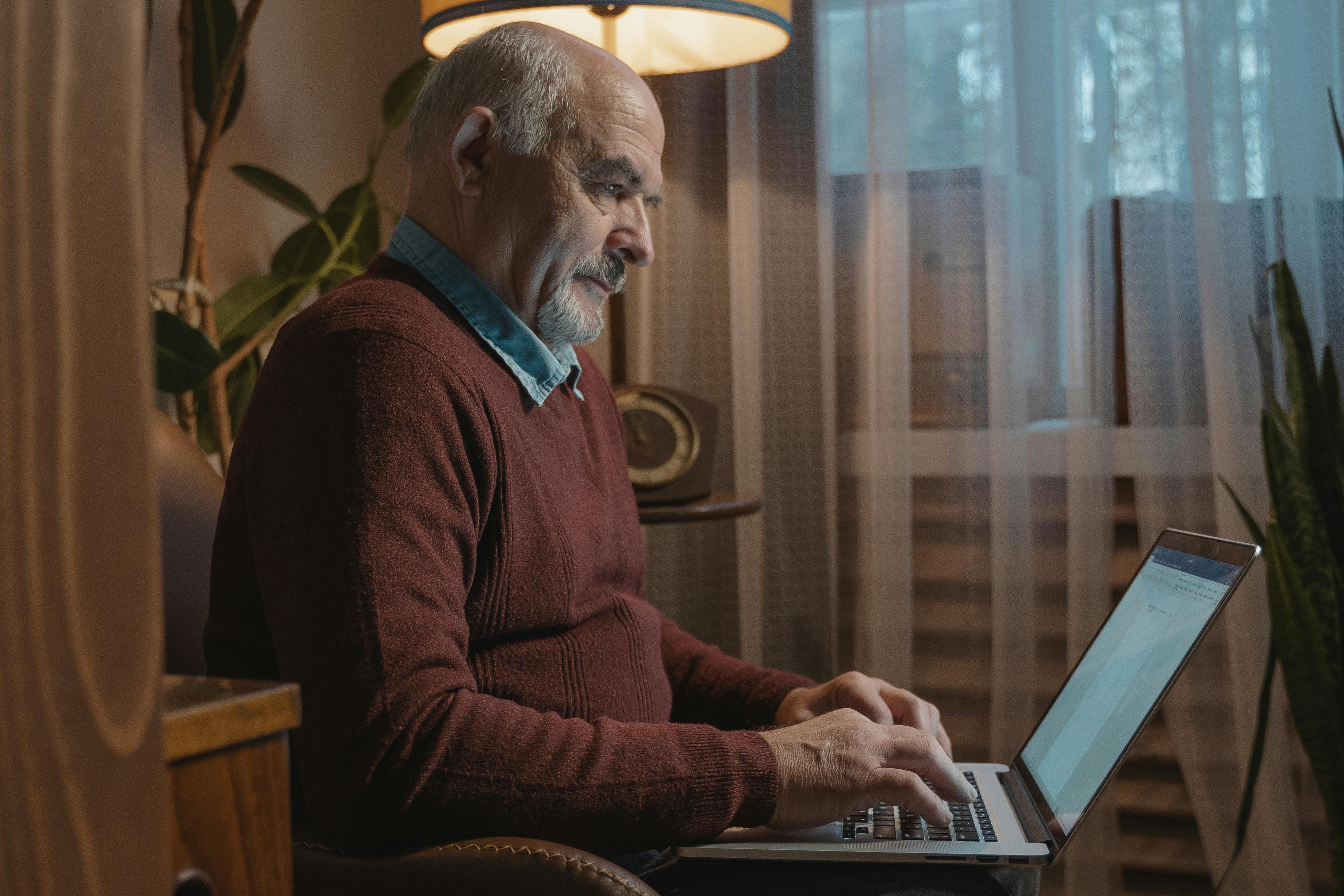 elderly man using gray laptop