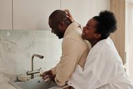 Man in Beige Sweater Kissing Woman in White Sweater