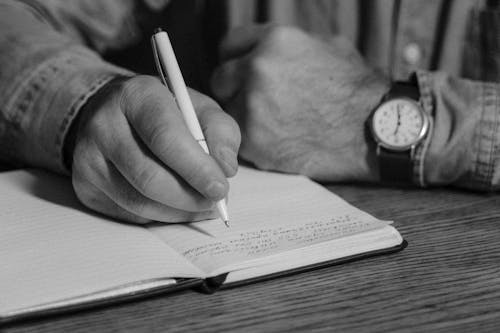 Free Monochrome Photo of Person Writing on a Journal  Stock Photo