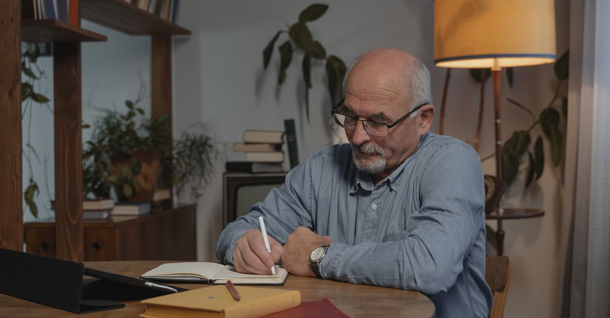 person journaling at dawn with warm lamp light and coffee