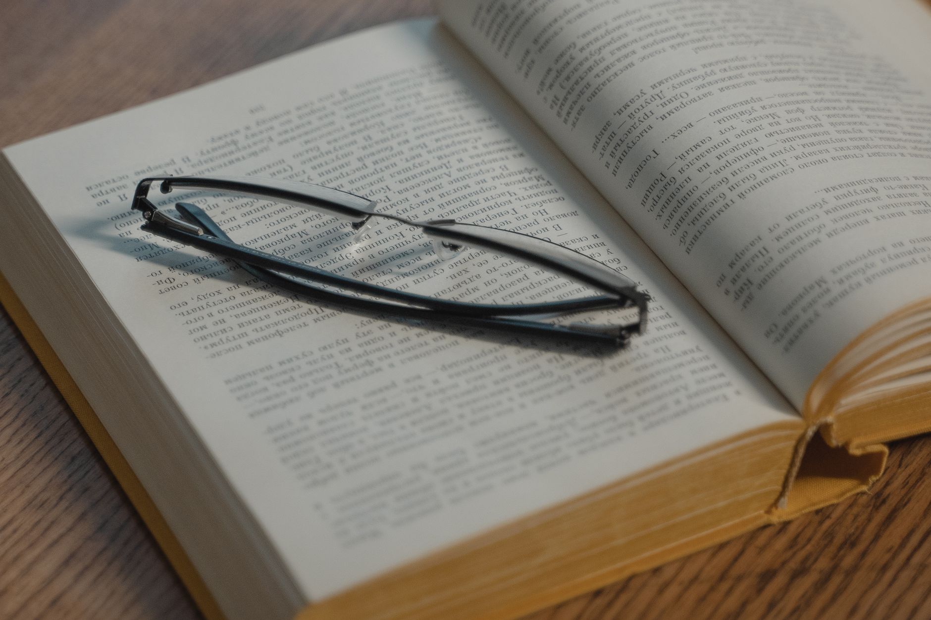 Close-up of glasses resting on an open book, perfect for reading themes.
