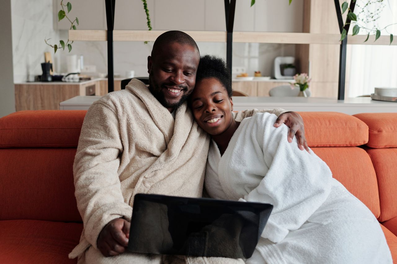 Relaxed smiling couple enjoying a hands-off morning at home with a laptop