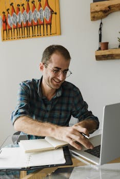 Portrait of a cheerful man working with a laptop in a cozy home office.