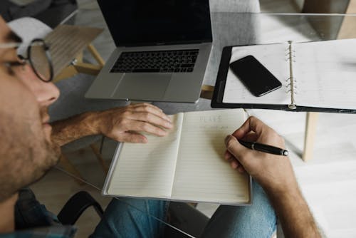 Man Making Notes in Notebook