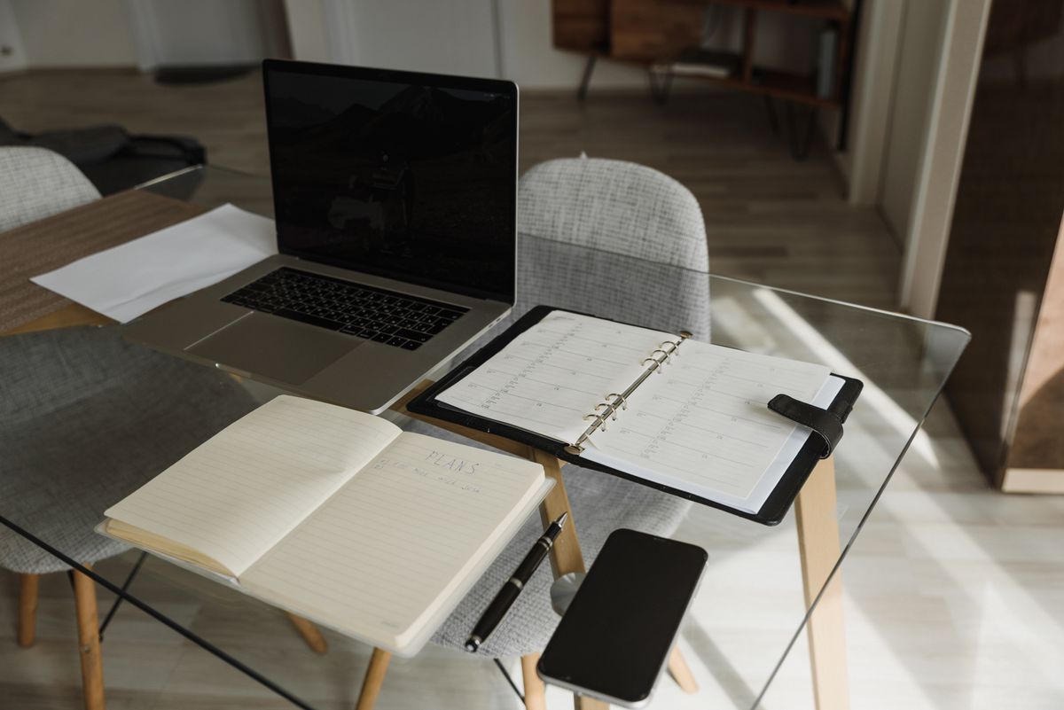 Organised desk with laptop, notebook and planner for content scheduling