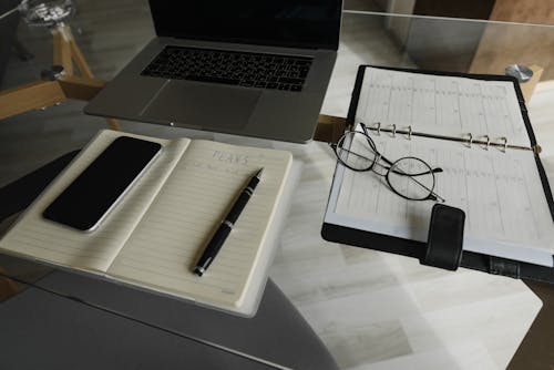 Macbook Pro à Côté Du Stylo Noir Et Argenté Sur Papier D'imprimante Blanc