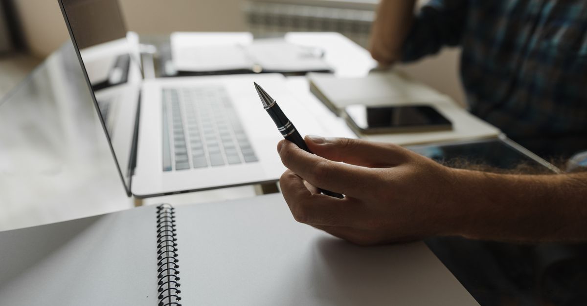 Person Holding a Pen · Free Stock Photo