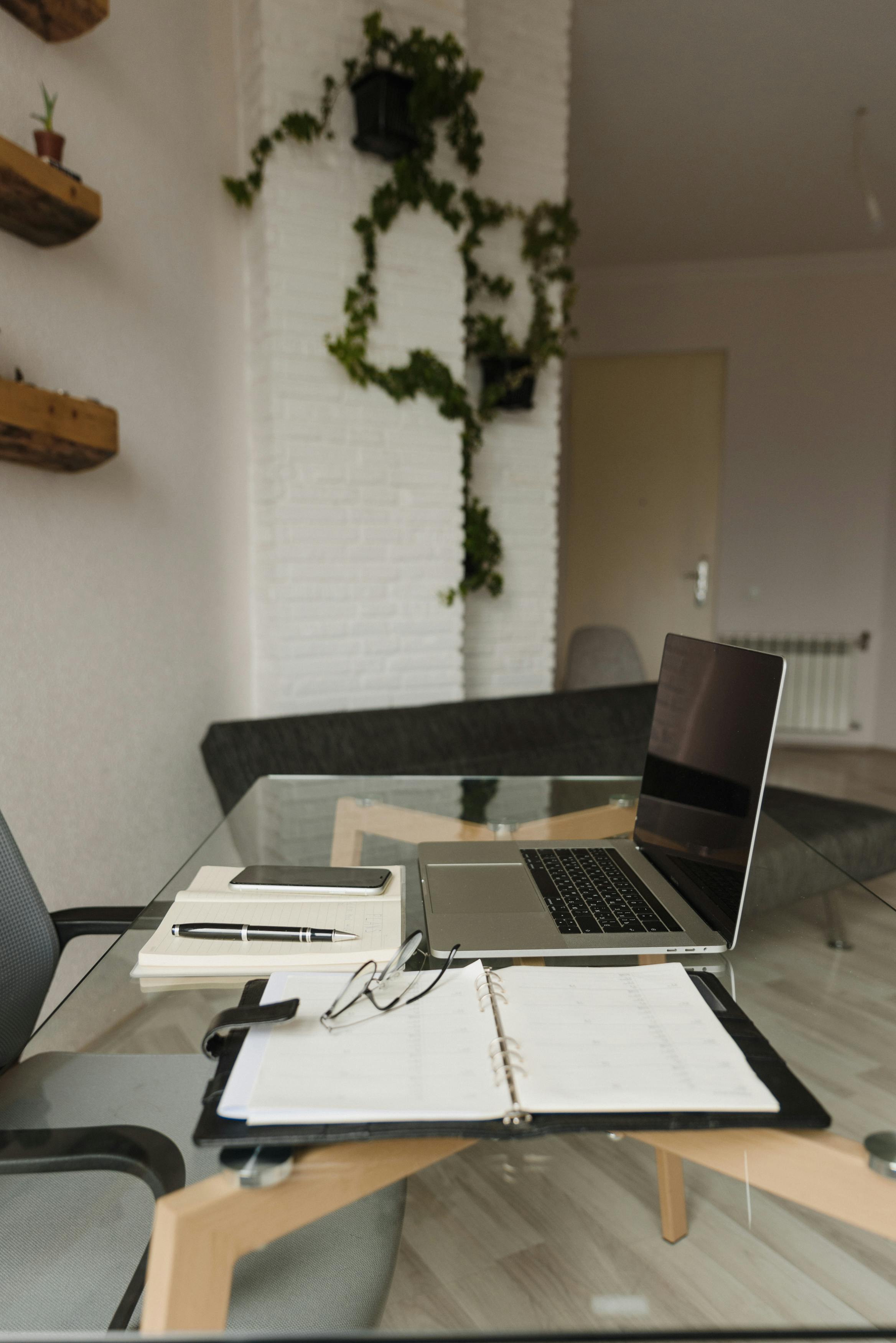 Young mother working on laptop in a bright modern home office while child draws nearby