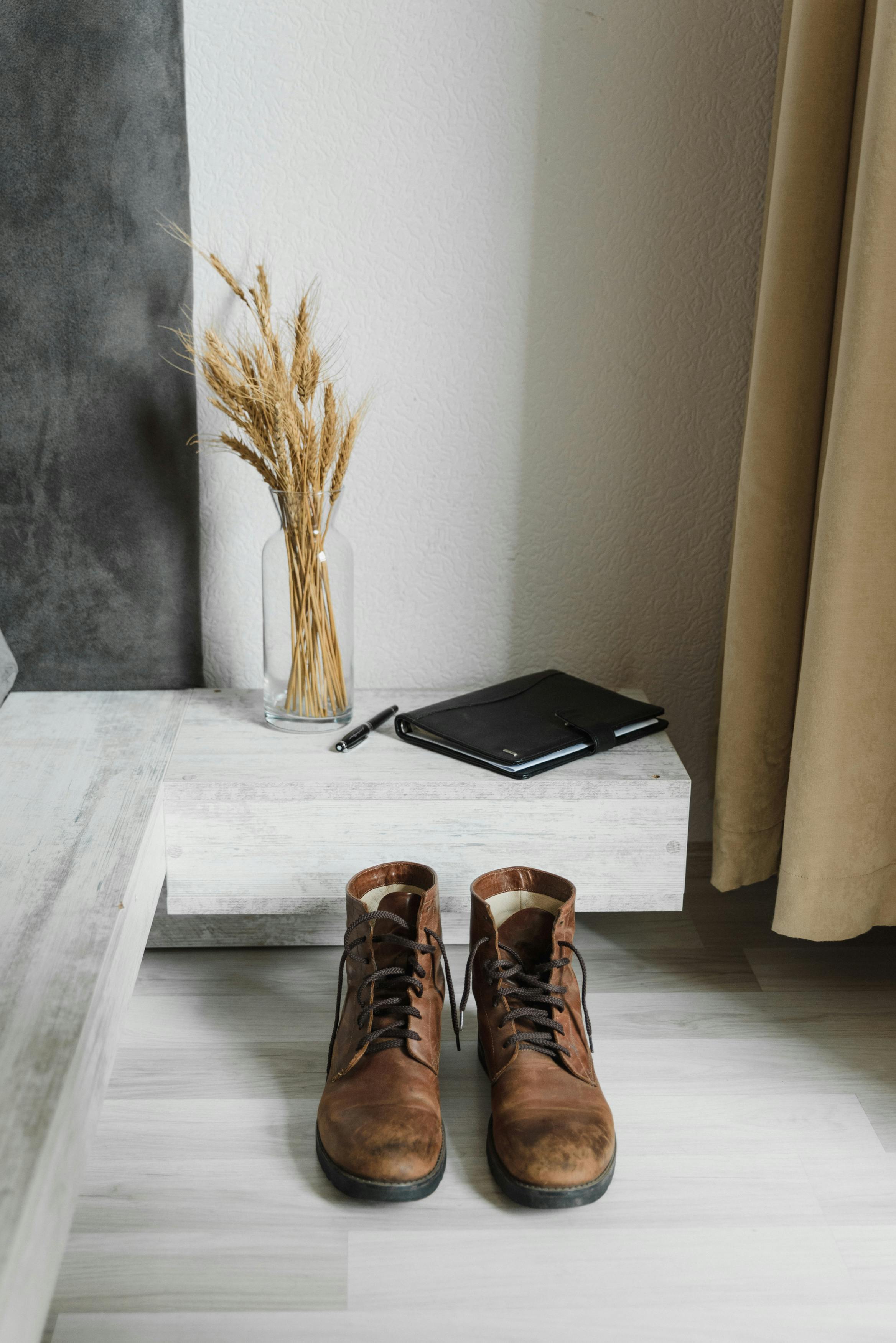 brown leather boots beside black laptop computer