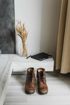 Worn brown leather boots on a wooden floor — photo by Arina Krasnikova on Pexels